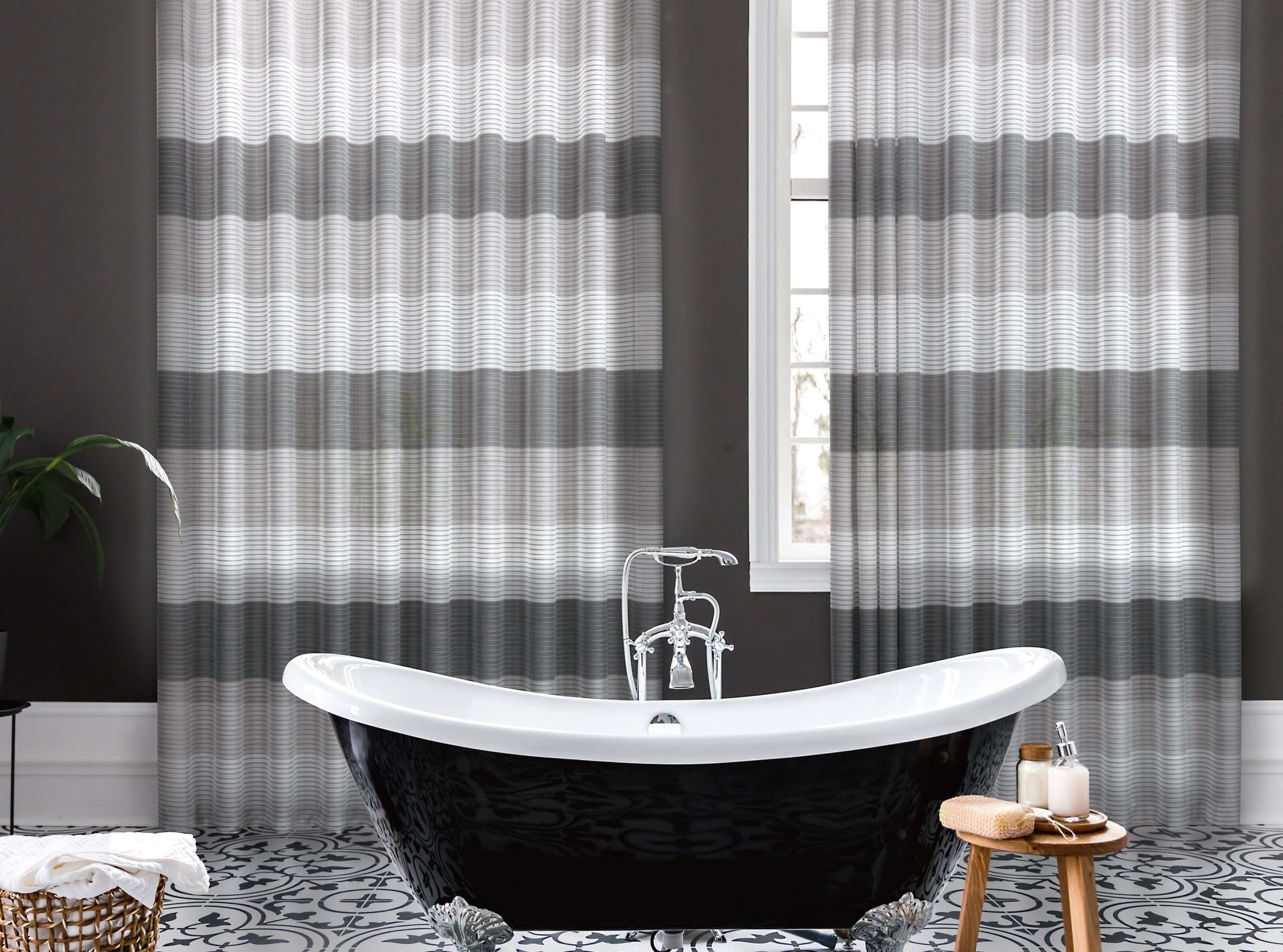 Vasca da bagno posizionata davanti a delle tende da interno ad onda con motivi a righe orizzontali color grigio, bianco e beige modello Picasso